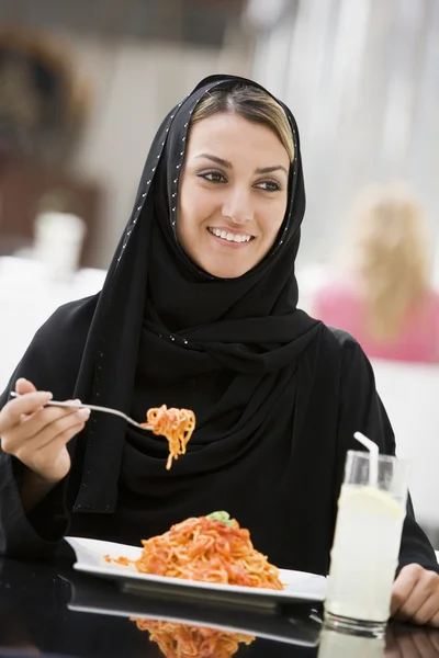 Une femme du Moyen-Orient dégustant un repas dans un restaurant — Photo
