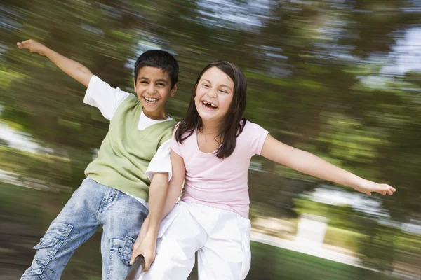 Dos niños divirtiéndose en la rotonda — Foto de Stock