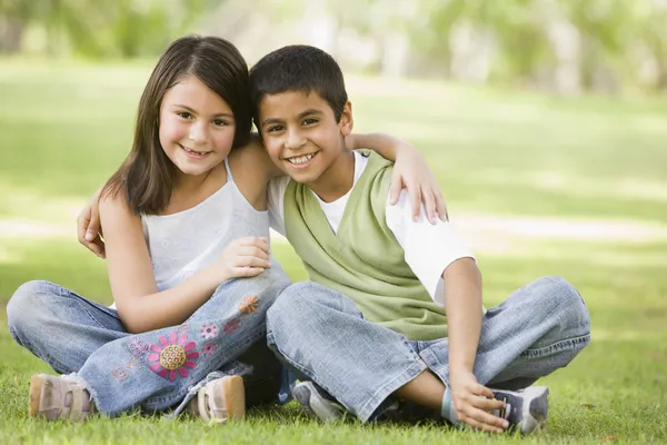 Dvě děti, které sedí v parku — Stock fotografie