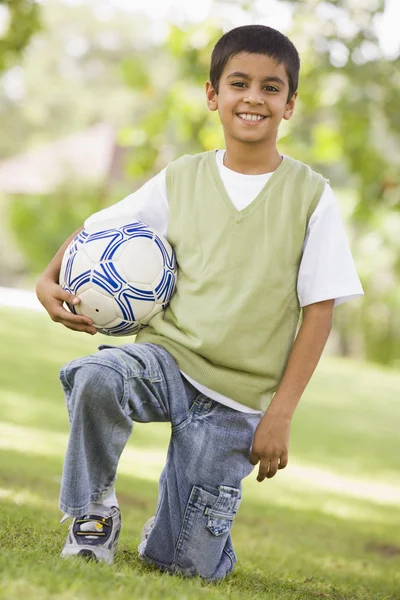 男孩抱着足球期待相机 — 图库照片