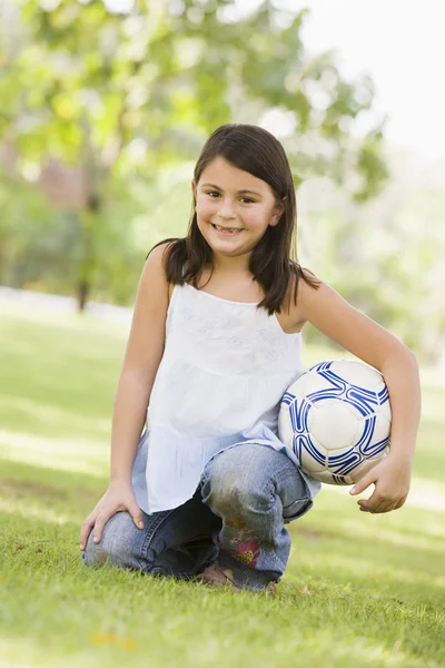 Дівчина тримає футбол у парку — стокове фото