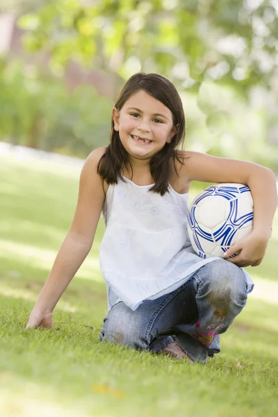 Dziewczyna w parku trzymając piłki nożnej — Zdjęcie stockowe