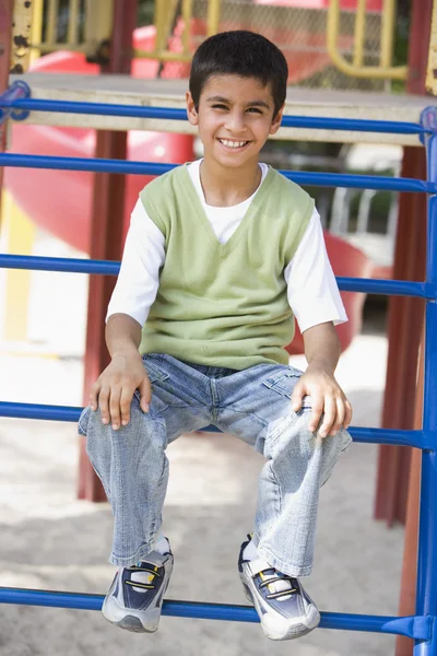 Junge Sitzt Auf Klettergerüst Auf Spielplatz — Stockfoto