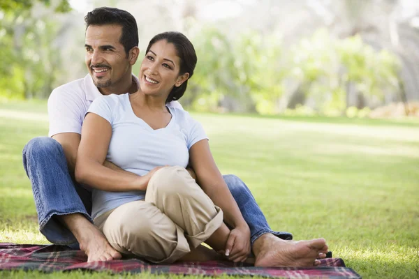 Couple relaxing in park sitting on blanket