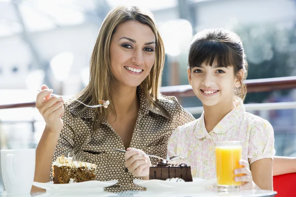 Mother and daughter eating cake in cafe — Stock Photo, Image