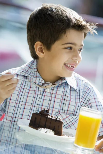 男孩在咖啡厅吃块巧克力蛋糕 — 图库照片