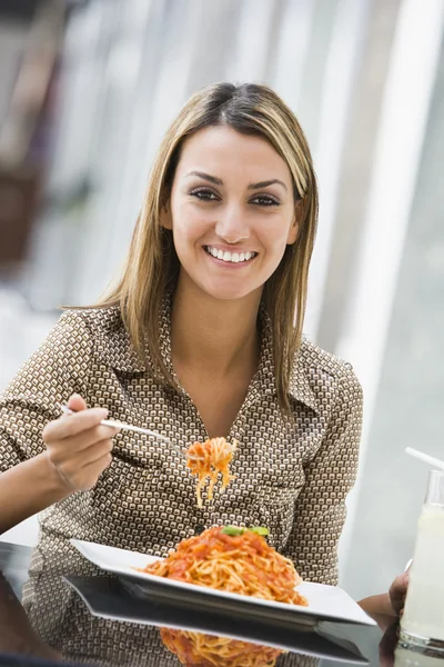 カフェでパスタのプレートを食べる女性 — ストック写真