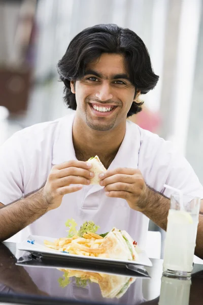 男子吃板的三明治在咖啡厅 — 图库照片