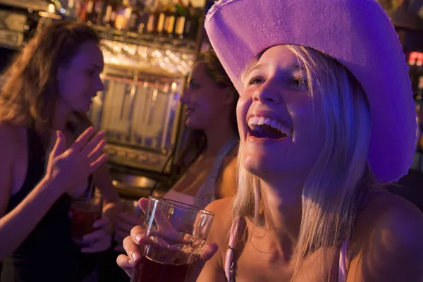 Девушка в ковбойской шляпе смеется над ночным клубом — стоковое фото