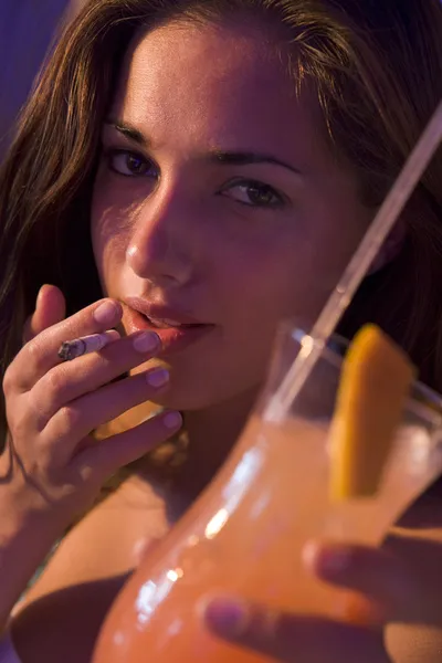 年轻女子饮酒和吸烟在一家酒吧的特写 — 图库照片