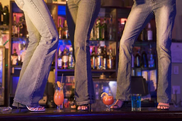 Trzy młode kobiety, taniec na barze licznik — Zdjęcie stockowe