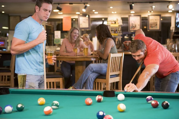 Two young men playing pool at a bar — Stock Photo, Image