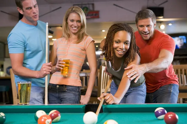 Ung man undervisning en ung kvinna att spela pool — Stockfoto