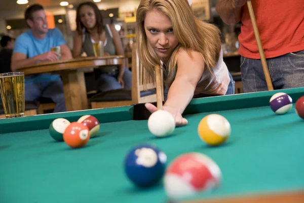 Junge Frau spielt Pool in einer Bar — Stockfoto