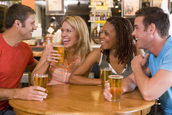 集团的年轻朋友喝酒和栏中笑 — 图库照片