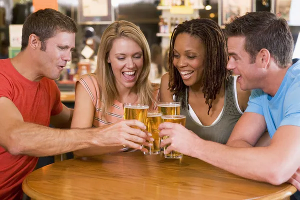 年轻的朋友在一家酒吧干杯的组 — 图库照片