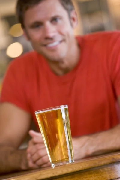 Молодий чоловік розслабляється в барі з пивом — стокове фото