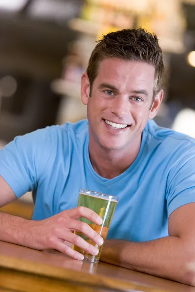 Giovane uomo godendo di una birra in un bar — Foto Stock