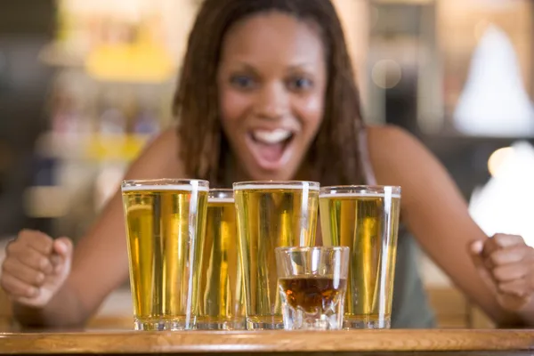 Mujer joven mirando con entusiasmo una ronda de cervezas —  Fotos de Stock