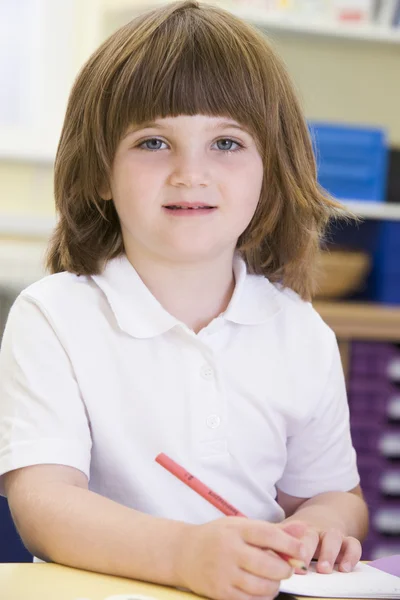 Ein Schulmädchen sitzt in einer Grundschulklasse — Stockfoto