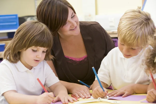 Schoolchildren and their teacher in a primary class — Stock Photo, Image