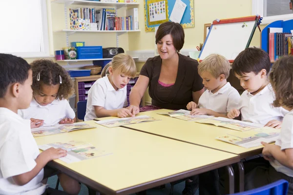 Schoolkinderen en hun leraar lezen in primaire klasse — Stockfoto