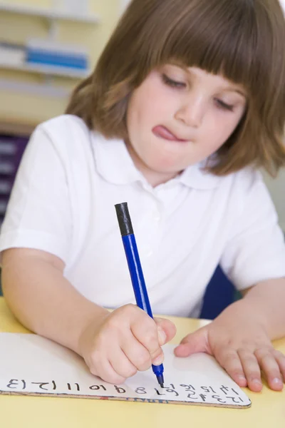 Κορίτσι Μαθαίνοντας να γράψετε τους αριθμούς στην πρωτοβάθμια κατηγορία — Φωτογραφία Αρχείου