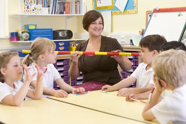 Crianças em idade escolar e seu professor em uma classe primária — Fotografia de Stock