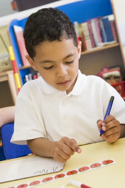 Garçon apprendre à écrire des nombres dans la classe primaire — Photo