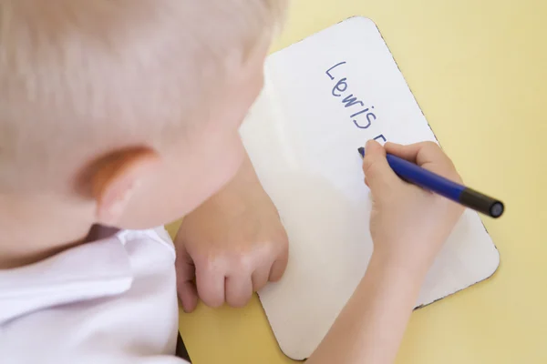 Chłopiec Nauczyć Pisać Nazwę Klasy Podstawowej — Zdjęcie stockowe