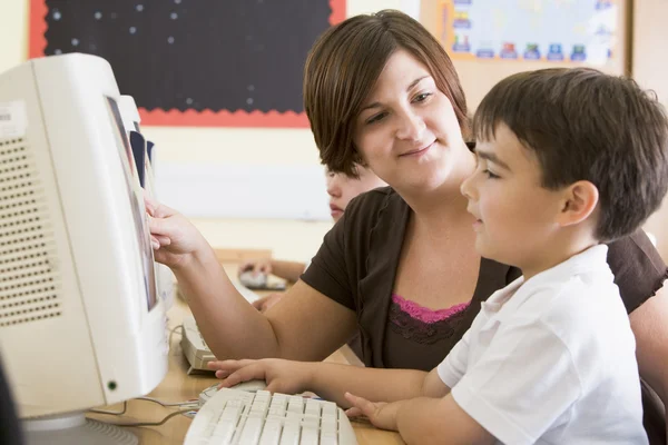 一个男孩和他的老师在小学阶段的计算机上工作 — 图库照片