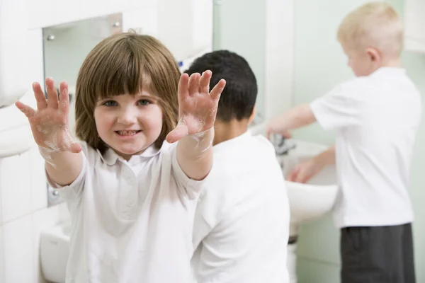 Uma menina exibindo suas mãos em um banheiro da escola primária — Fotografia de Stock
