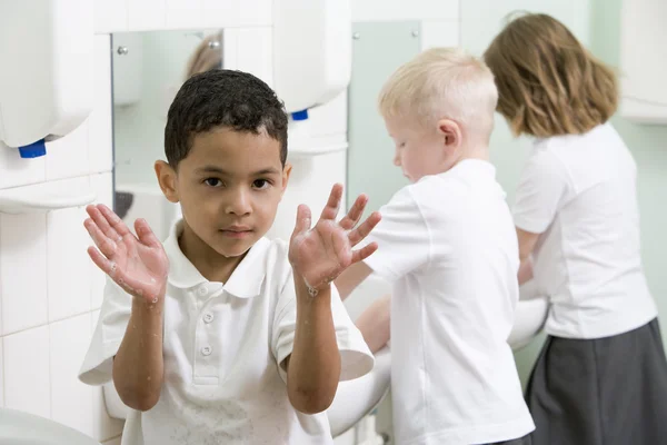 Chłopiec wyświetlanie jego ręce w łazience Szkoła podstawowa — Zdjęcie stockowe