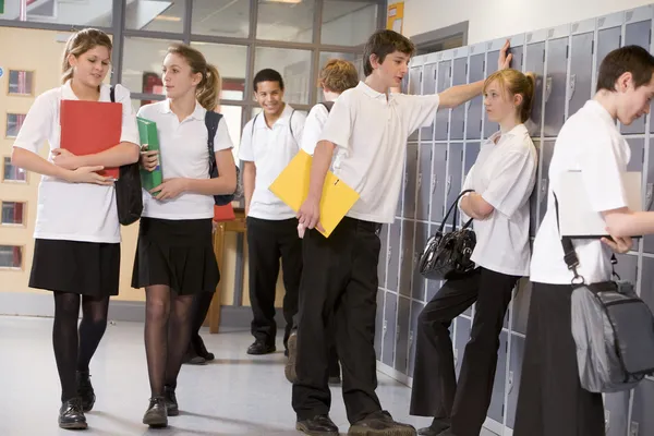 Estudantes do ensino médio por armários no corredor da escola — Fotografia de Stock