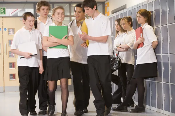 Teenage boys clustered around a girl at school — Stock Photo, Image