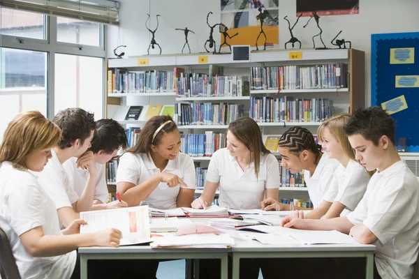 Schoolchildren studying in school library — Stock Photo, Image