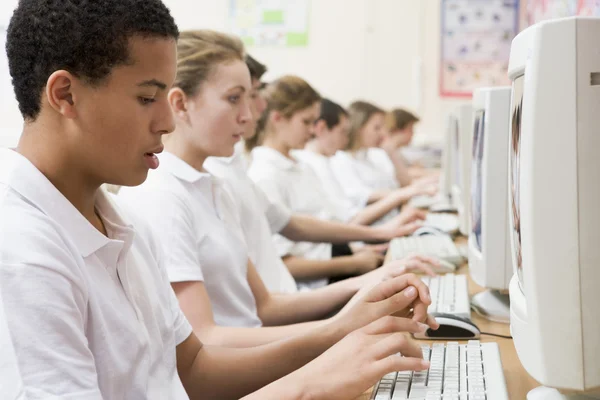 Fila de escolares que estudian frente a una computadora —  Fotos de Stock