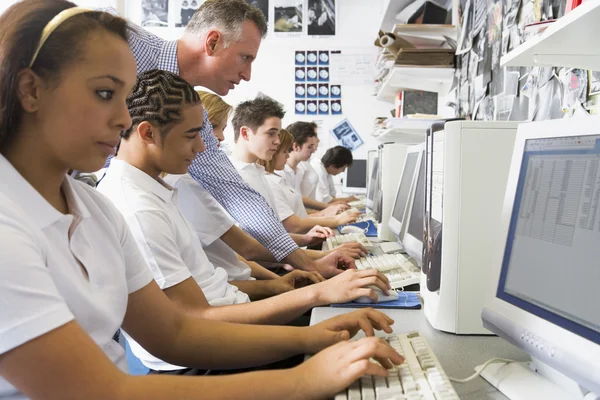 Ряд школьников, занимающихся за компьютером — стоковое фото