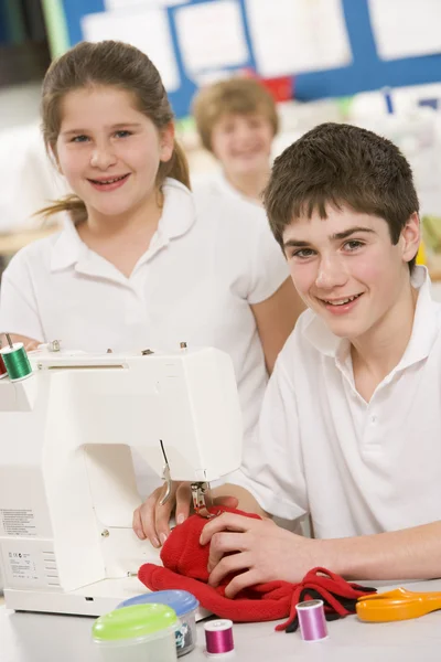 Schoolchildren using a sewing machine in sewing class — Stock Photo, Image