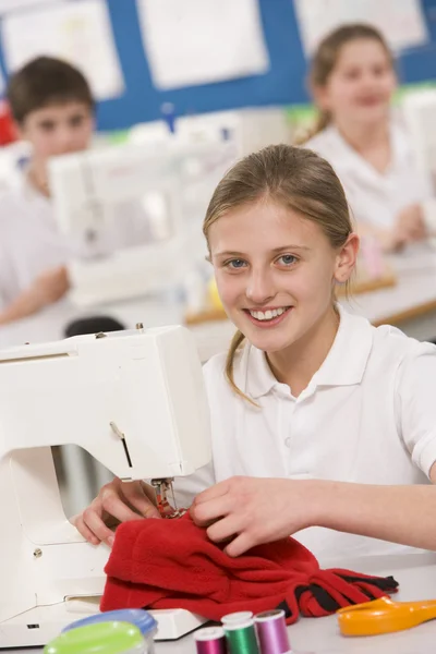 Schoolgirl using a sewing machine in sewing class — Stock Photo, Image