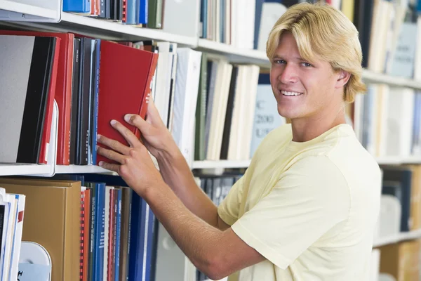 Студент университета выбирает книгу из библиотеки — стоковое фото
