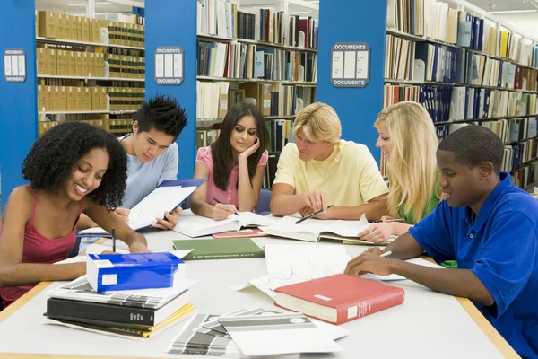 Skupina vysokoškolských studentů pracovat v knihovně — Stock fotografie