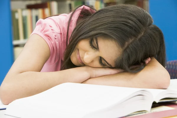Uitgeput universiteitsstudent in bibliotheek — Stockfoto