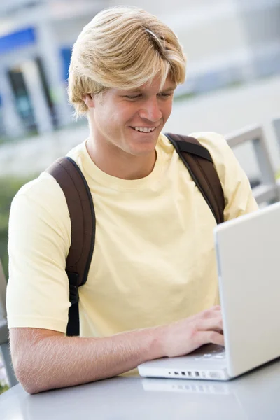 Estudante masculino usando laptop fora — Fotografia de Stock