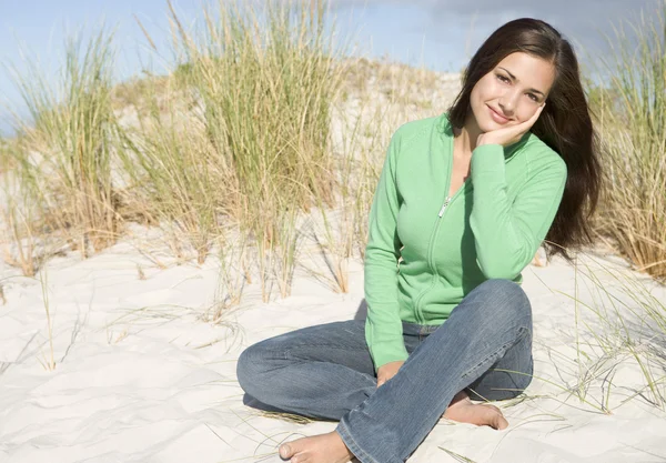 Mujer joven relajándose entre dunas — Foto de Stock