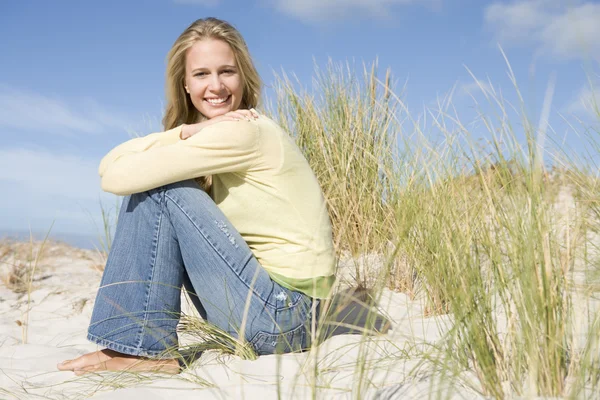 Девушка, сидящая среди дюн — стоковое фото
