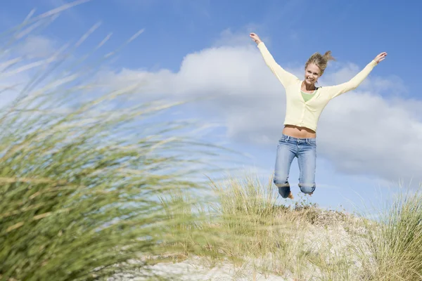 Ung kvinna hoppa bland sanddyner — Stockfoto