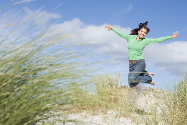 Ung kvinna hoppa bland sanddyner — Stockfoto