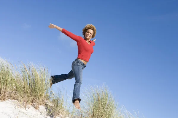 Mujer Joven Saltando Entre Dunas Arena Contra Cielo Azul — Foto de Stock