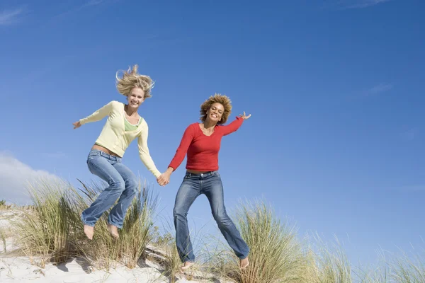 Två Unga Kvinnor Som Hoppar Luften Stranden — Stockfoto